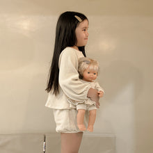 Load image into Gallery viewer, Young girl holding a baby doll against a plain background

